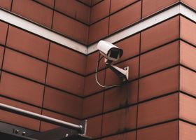 pexels-photo-5213883-5213883 Security camera monitoring a red brick building exterior, symbolizing modern surveillance in Germany.